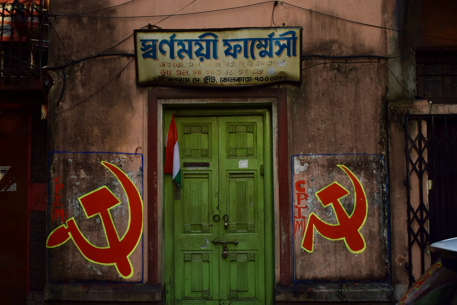Political mural flanking a pharmacy's green door