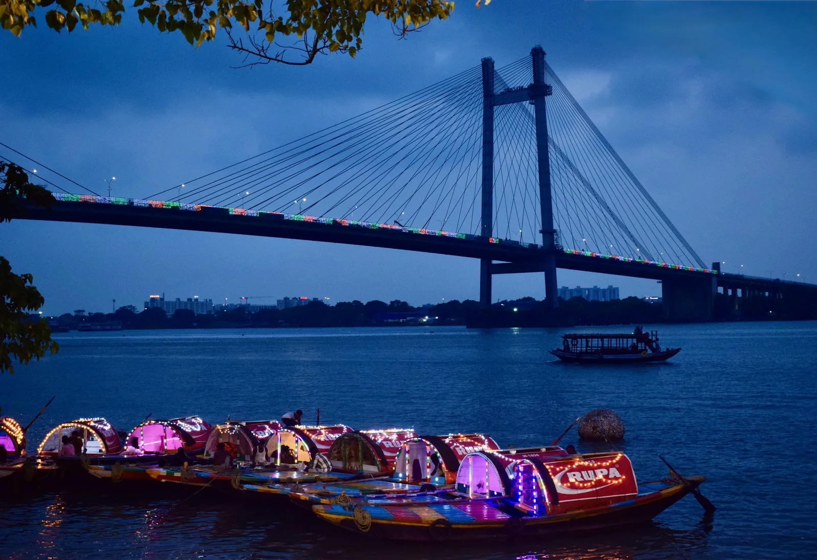 Lit pleasure boats at Princep Ghat Vidyasagar Setu Kolkata