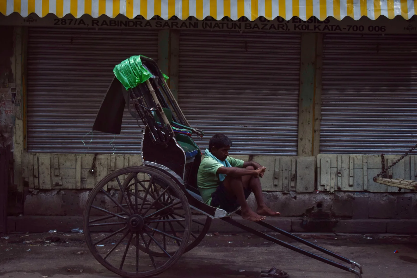 Rickshaw puller resting on Rabindra Sarani